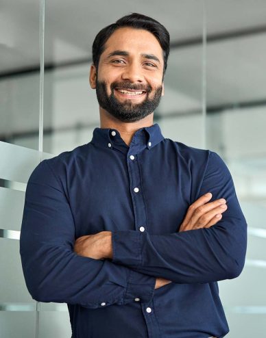 happy-confident-indian-businessman-standing-in-off-DCXP57R